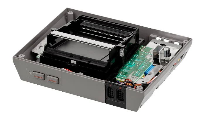 Geöffnete Retro-Konsole mit sichtbarem Modulschacht und Platine
